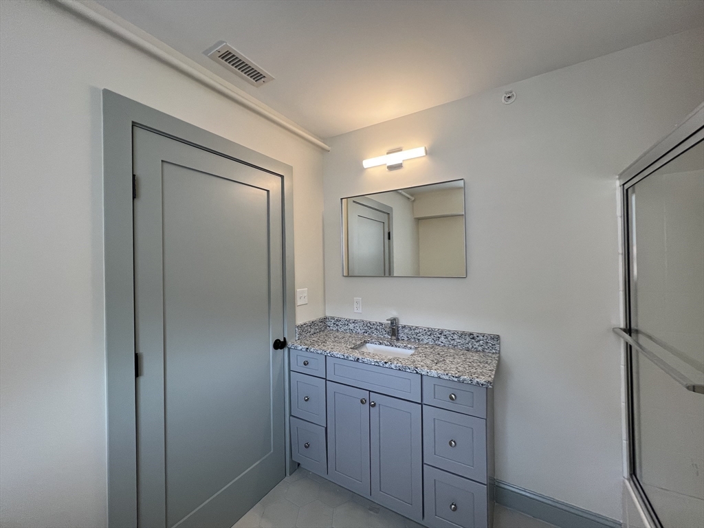 160 Seabury Street, Unit 29 Fall River, MA 02720 - Photo 16 of 17 a bathroom with a granite countertop sink mirror and cabinets
