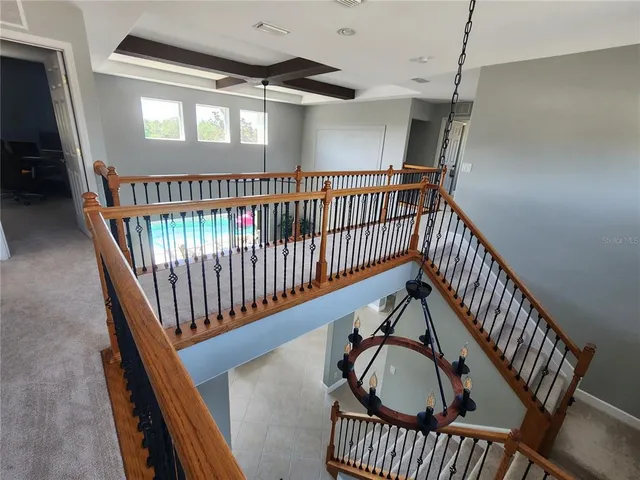a view of staircase with railing and a window