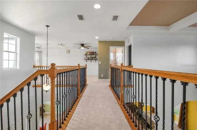 a view of a hallway with wooden floor and stairs