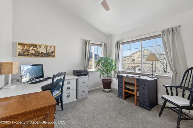 a view of a workspace with furniture and a window