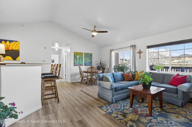 a living room with furniture a dining table and a potted plant