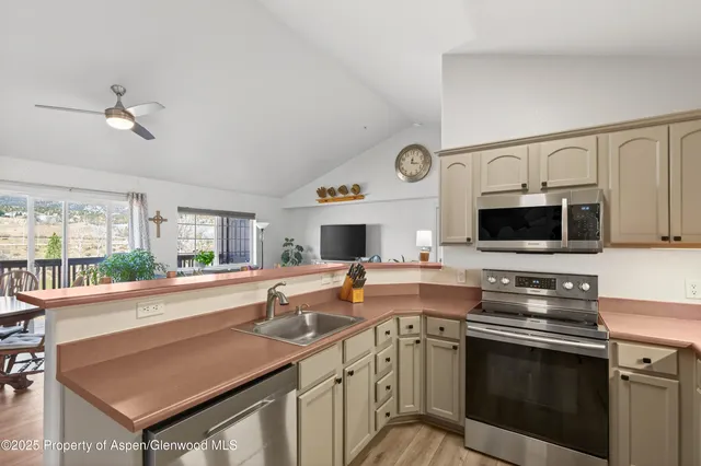 a kitchen with stainless steel appliances a stove microwave and sink