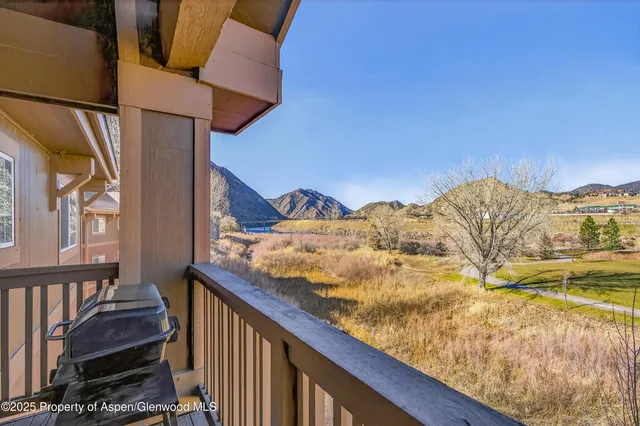 a view of a balcony with chair and wooden floor