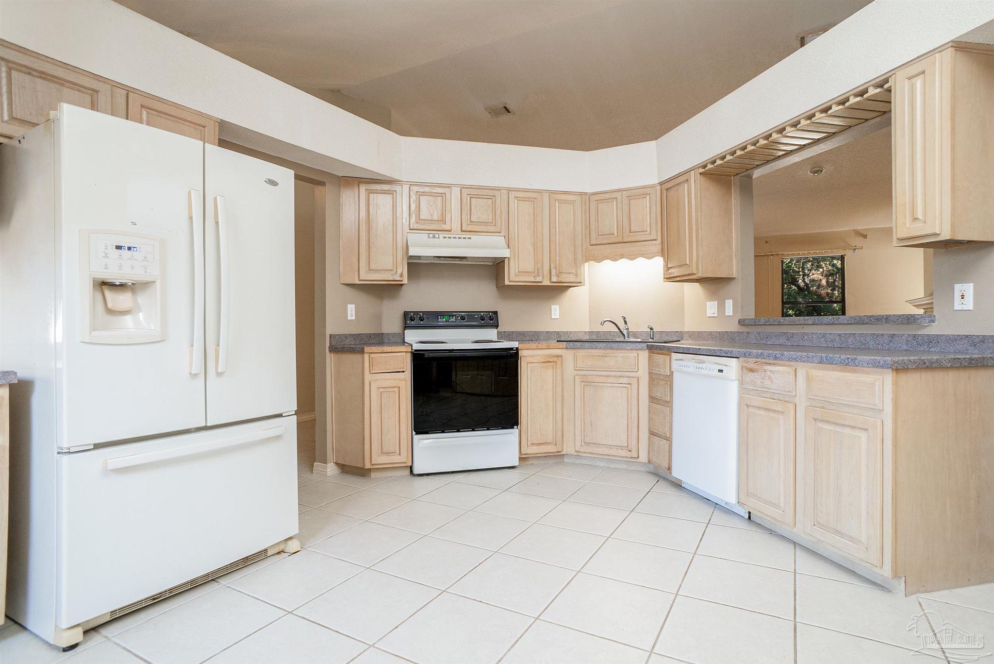 1860 Sparrow Lane Navarre, FL 32566 - Photo 23 of 43 a kitchen with white cabinets and white appliances
