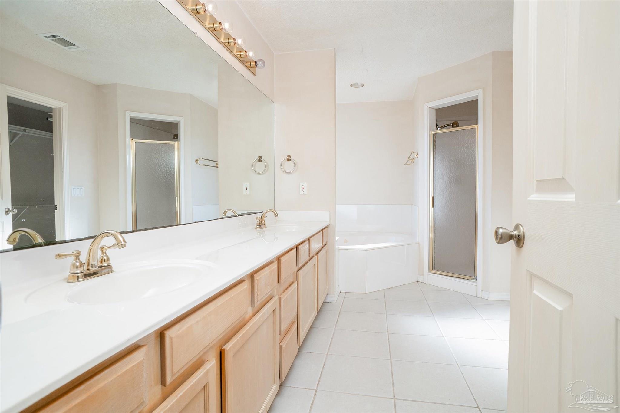 1860 Sparrow Lane Navarre, FL 32566 - Photo 31 of 43 a bathroom with a double vanity sink and mirror