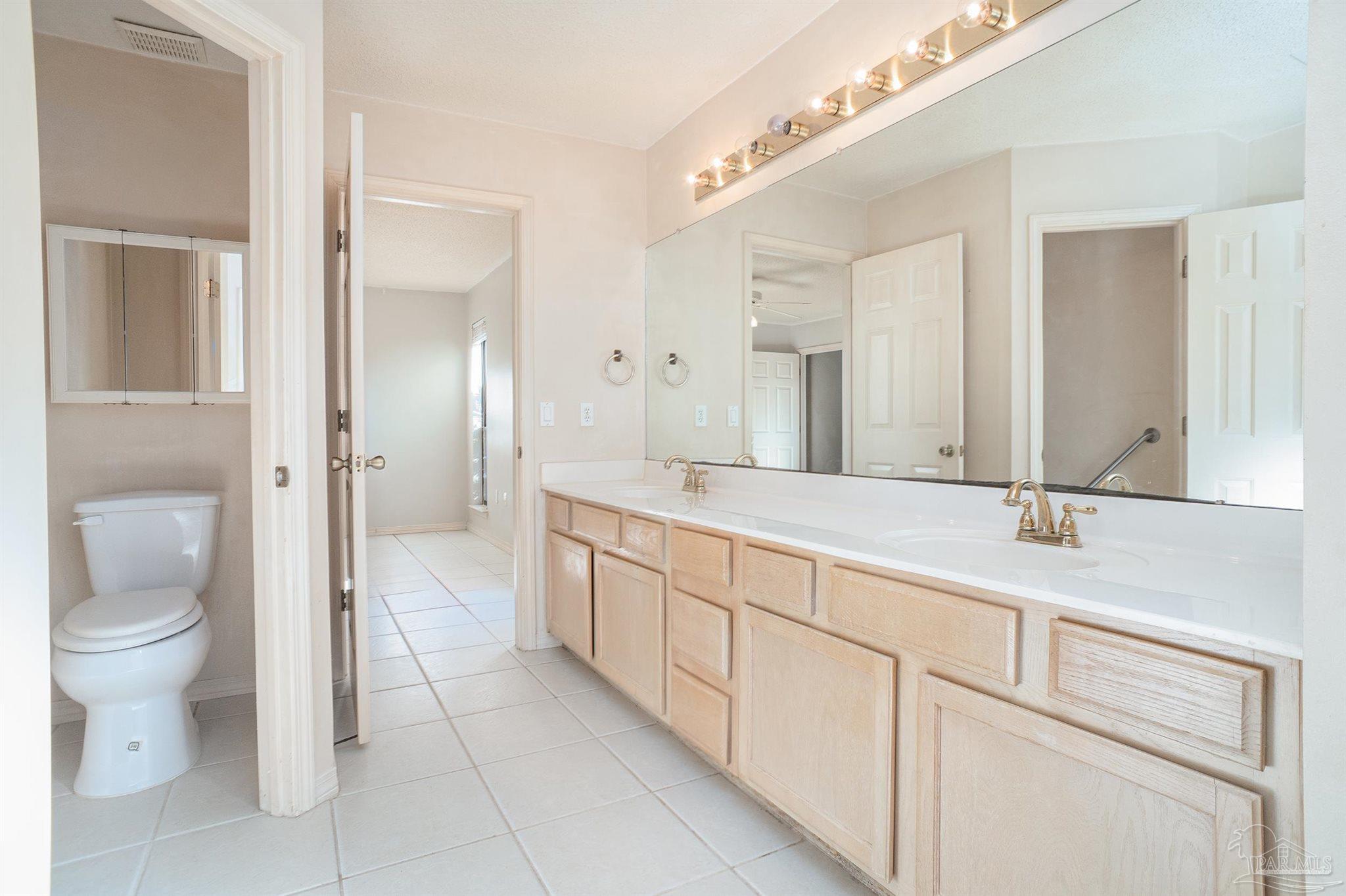 1860 Sparrow Lane Navarre, FL 32566 - Photo 34 of 43 a spacious bathroom with a granite countertop sink mirror and a toilet