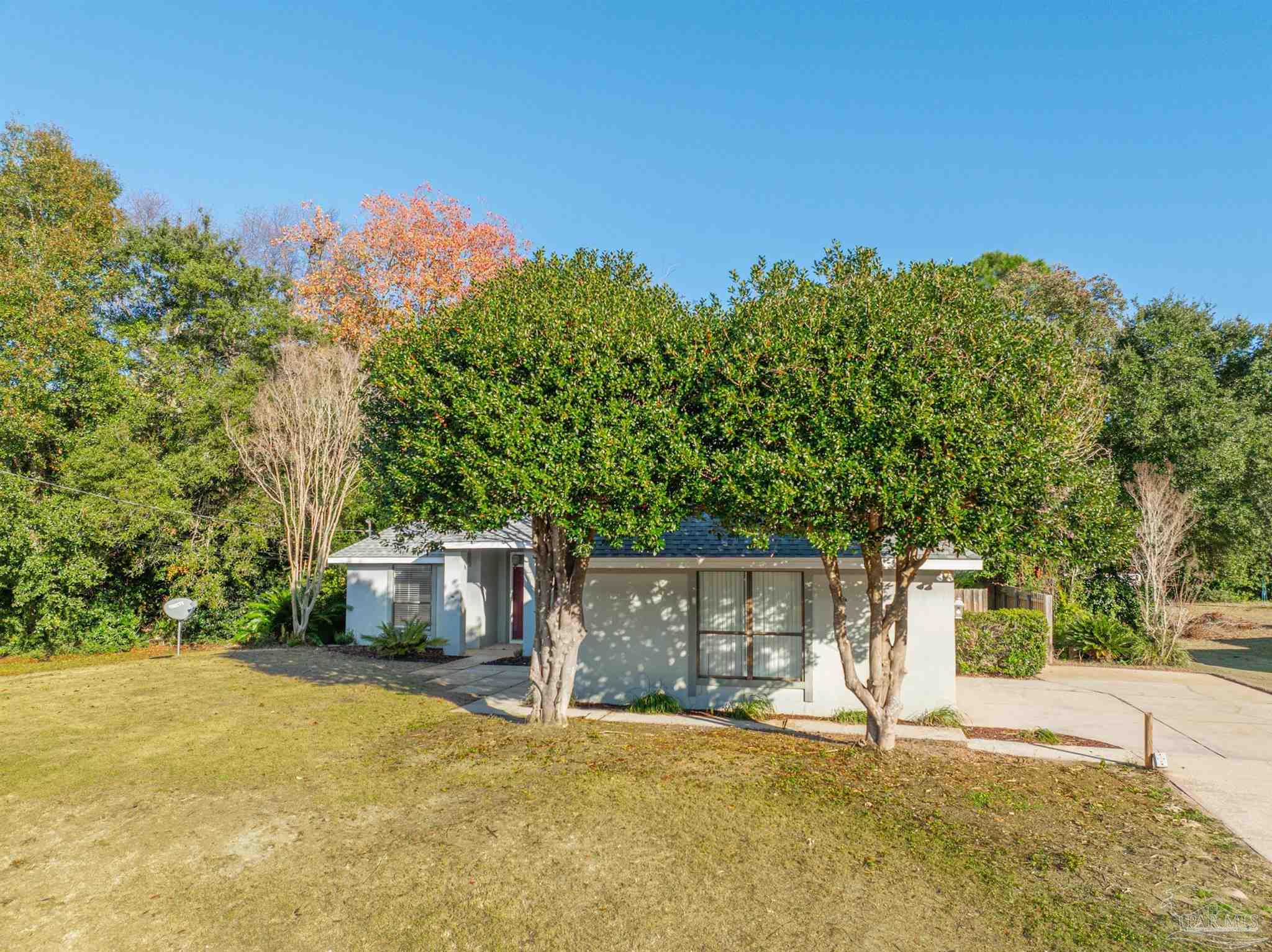1860 Sparrow Lane Navarre, FL 32566 - Photo 5 of 43 a front view of a house with a yard and trees