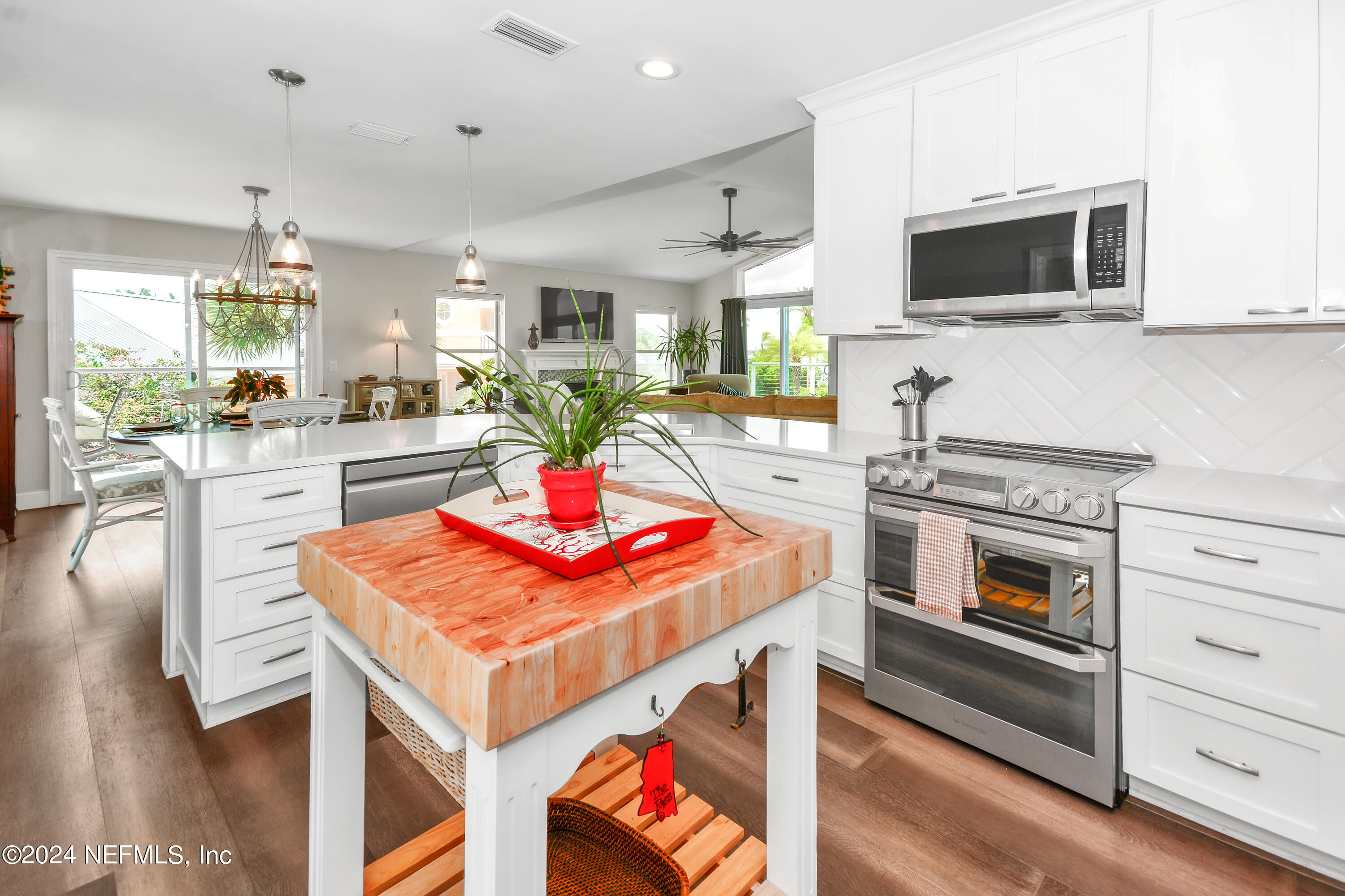 2740 Harbor Court St. Augustine, FL 32084 - Photo 16 of 53 a kitchen with stainless steel appliances kitchen island granite countertop a stove a sink and a microwave