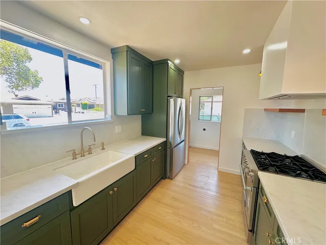 a kitchen with stainless steel appliances a sink and a large window