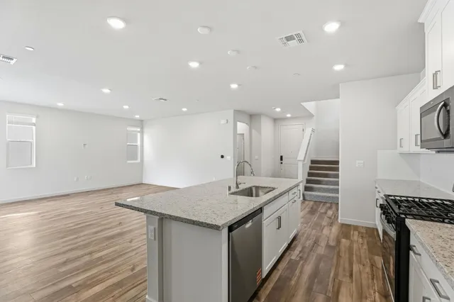 a kitchen with stainless steel appliances a stove a sink and a refrigerator