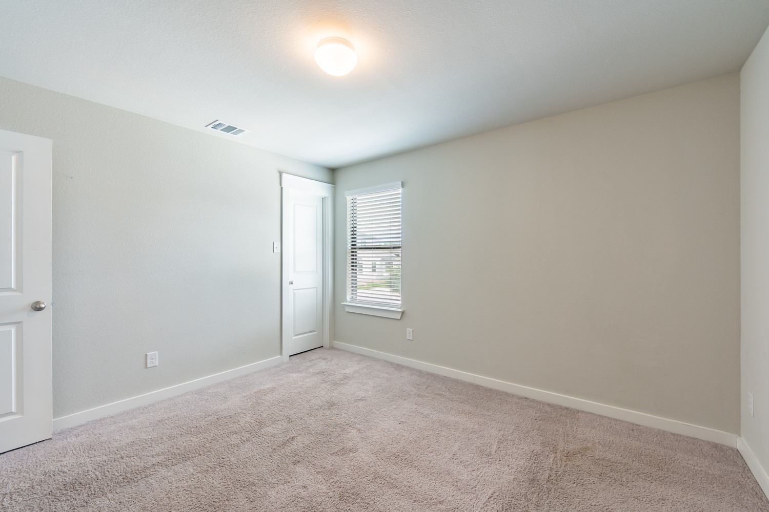 147 Waterside Road, Unit A Buda, TX 78610 - Photo 19 of 27 A well-proportioned bedroom with plush carpeting, ready for your personal touch.