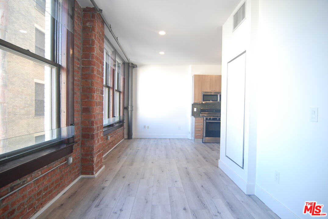 460 South Spring Street, Unit 608 Los Angeles, CA 90013 - Photo 11 of 31 a view of a hallway with wooden floor and a living room