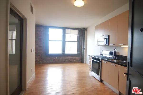 a kitchen with granite countertop a stove top oven sink and cabinets