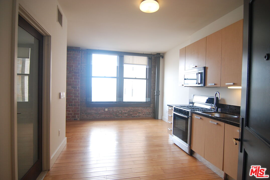 460 South Spring Street, Unit 608 Los Angeles, CA 90013 - Photo 31 of 31 a kitchen with granite countertop a stove top oven sink and cabinets