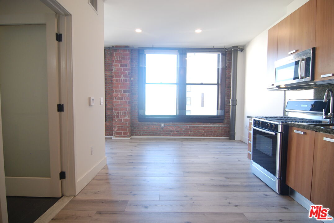 460 South Spring Street, Unit 608 Los Angeles, CA 90013 - Photo 4 of 31 an empty room with wooden floor and windows