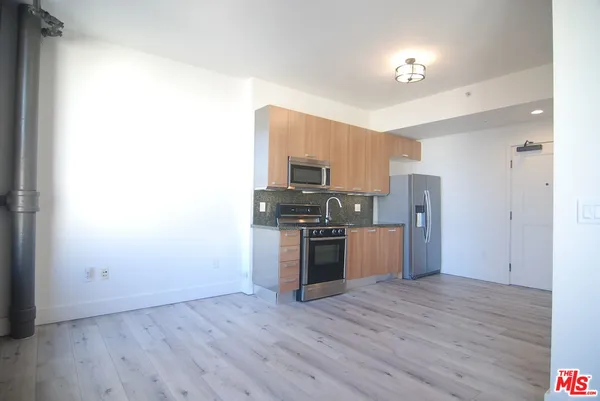 a kitchen with stainless steel appliances a refrigerator and a stove top oven