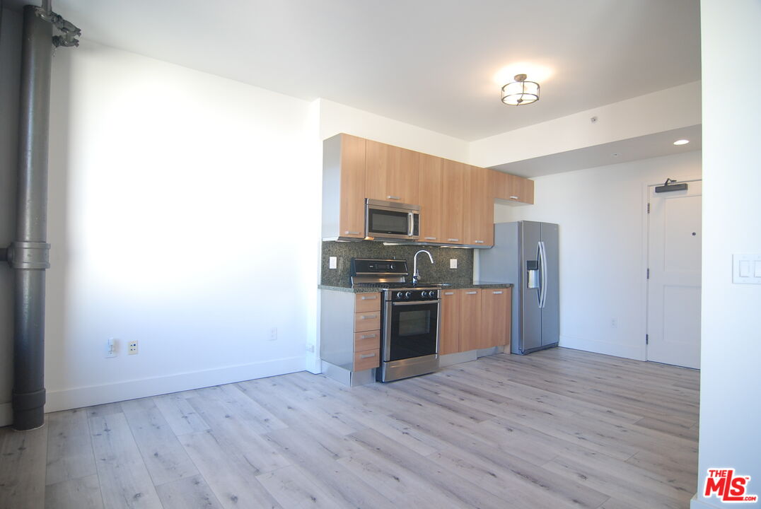 460 South Spring Street, Unit 608 Los Angeles, CA 90013 - Photo 7 of 31 a kitchen with stainless steel appliances a refrigerator and a stove top oven