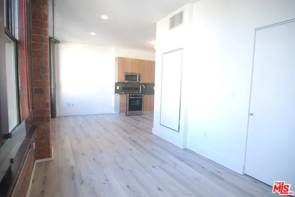 a view of a kitchen with a sink and a refrigerator