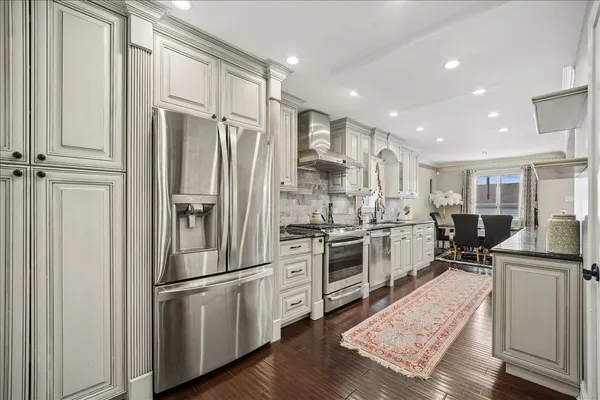 a kitchen with stainless steel appliances a refrigerator sink and stove top oven