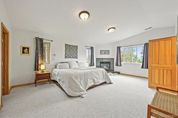 a spacious bedroom with a bed and a fireplace