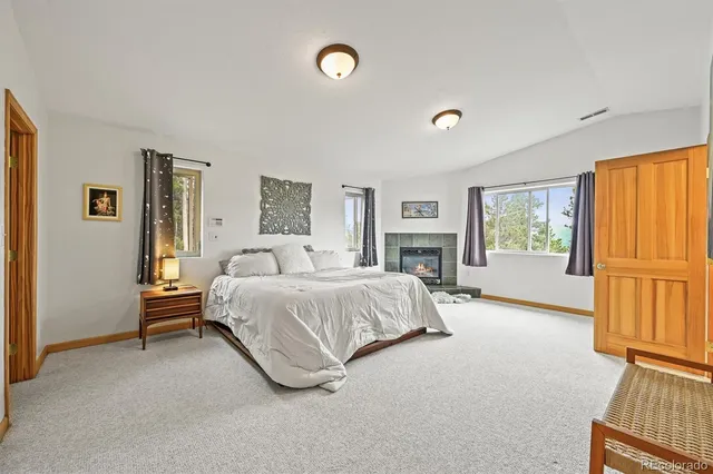 a spacious bedroom with a bed and a fireplace