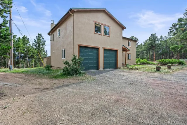 a view of a white house with a yard and plants