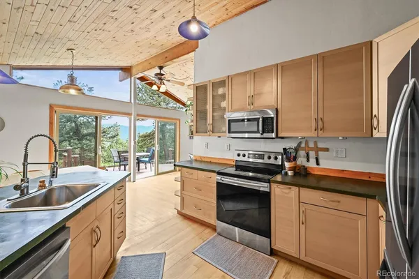 a kitchen with stainless steel appliances granite countertop a sink a stove and cabinets