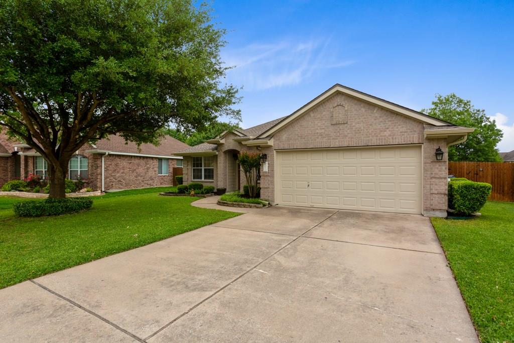 20213 Kearney Hill Road Pflugerville, TX 78660 - Photo 2 of 27 A well-maintained lawn and mature tree enhance the curb appeal of this charming brick home.