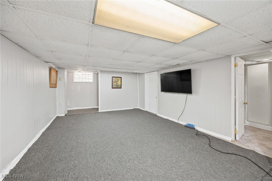 3368 Berea Road Cleveland, OH 44111 - Photo 21 of 26 Basement featuring a paneled ceiling, carpet flooring, and wooden walls