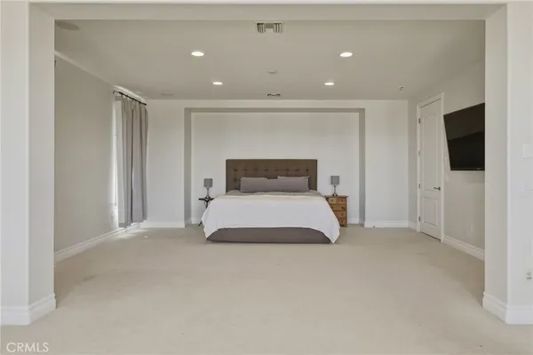 a bedroom with a bed and a flat screen tv