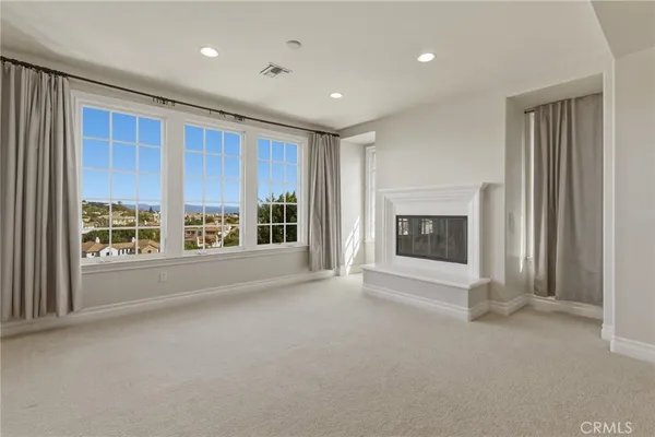 a view of an empty room with a fireplace and a window