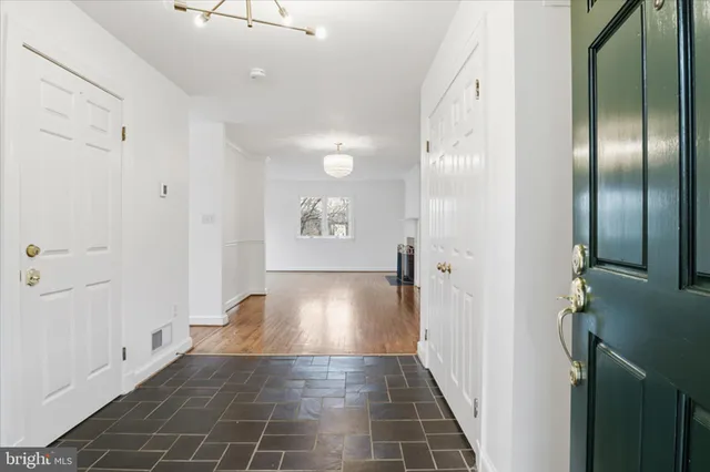 a view of a hallway with wooden floor and staircase