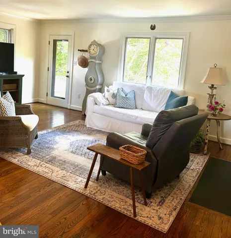 a living room with furniture a wooden floor and a large window