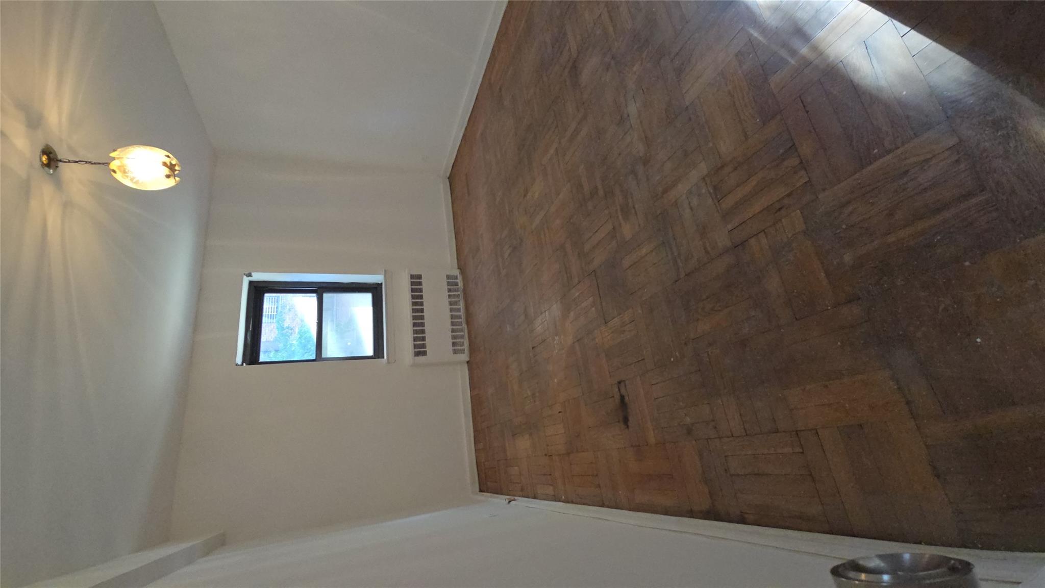 102-25 67th Road, Unit 1F Queens, NY 11375 - Photo 6 of 6 Spare room featuring dark parquet flooring and radiator heating unit