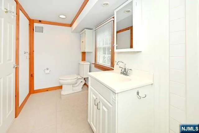 a bathroom with a sink a toilet and a mirror