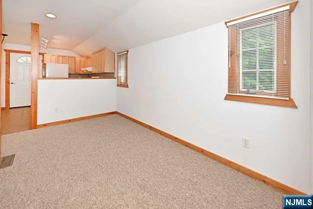 a view of a kitchen with wooden floor and a window