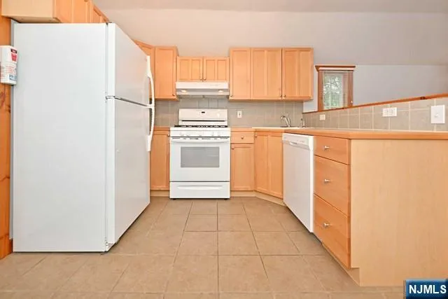 a kitchen with a refrigerator a stove a microwave and cabinets