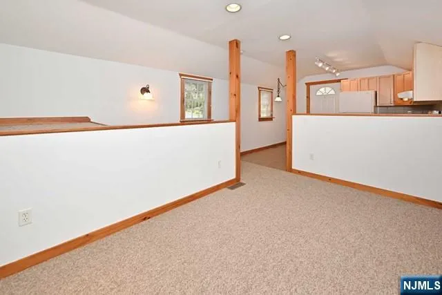 a view of kitchen with stainless steel appliances granite countertop cabinets and a wooden floor