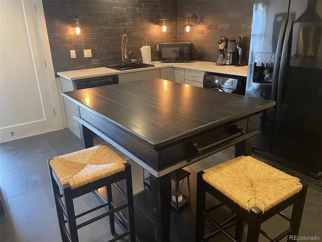 a view of a room with kitchen island a stove a table and chairs