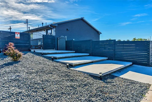 a view of a backyard with chairs and wooden fence