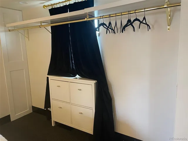 a view of walk in closet with clothes