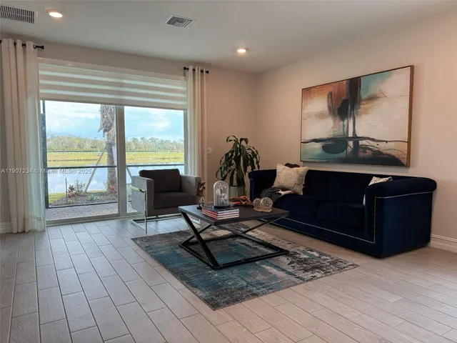 a large kitchen with kitchen island a sink dishwasher a stove and a refrigerator with wooden floor