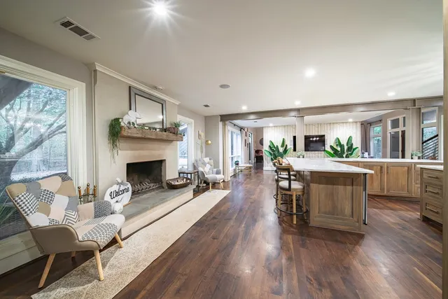 a living room with furniture a large window and wooden floor