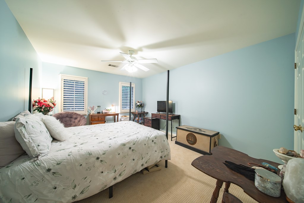 517 Double Churches Road Columbus, GA 31904 - Photo 49 of 96 a bedroom with a bed a chair and potted plant on the table