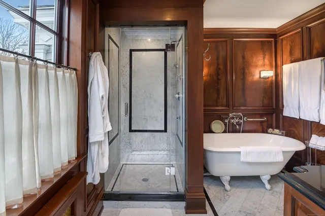 a bathroom with a tub a sink and a large mirror