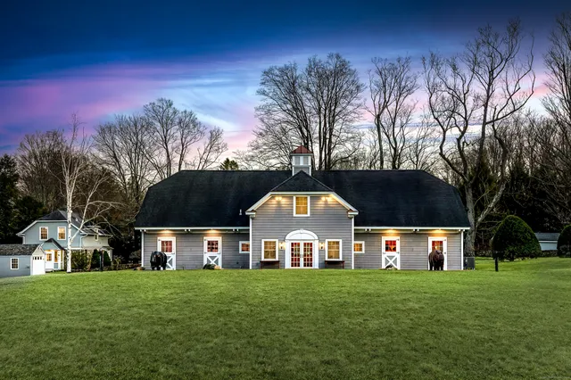 a view of a big house with a big yard and large trees
