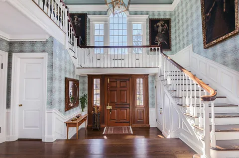 a view of entryway with wooden floor and front door