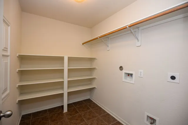 a view of walk in closet with empty racks