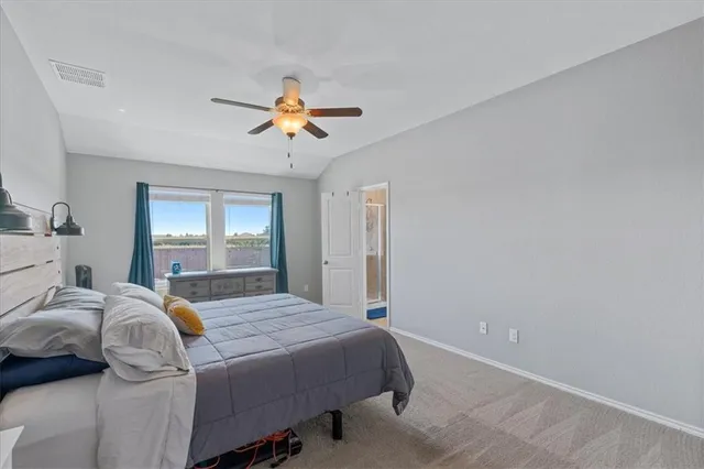 a bedroom with a bed ceiling fan and a window