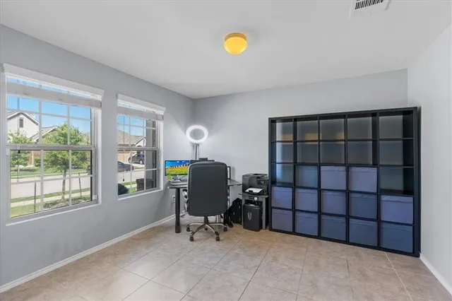 a view of a workspace with furniture and a window